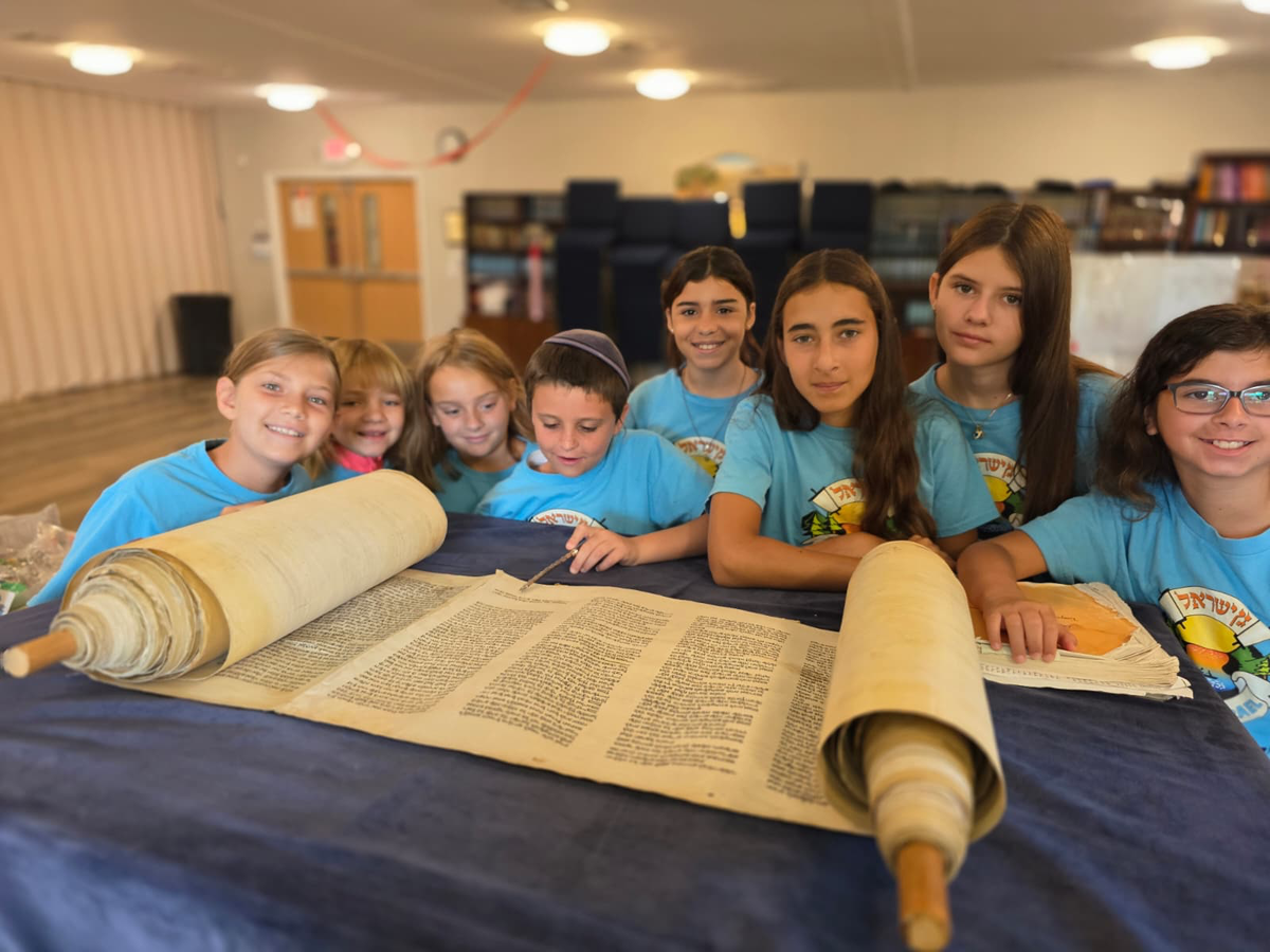 Hebrew School students reading from an open Torah scroll