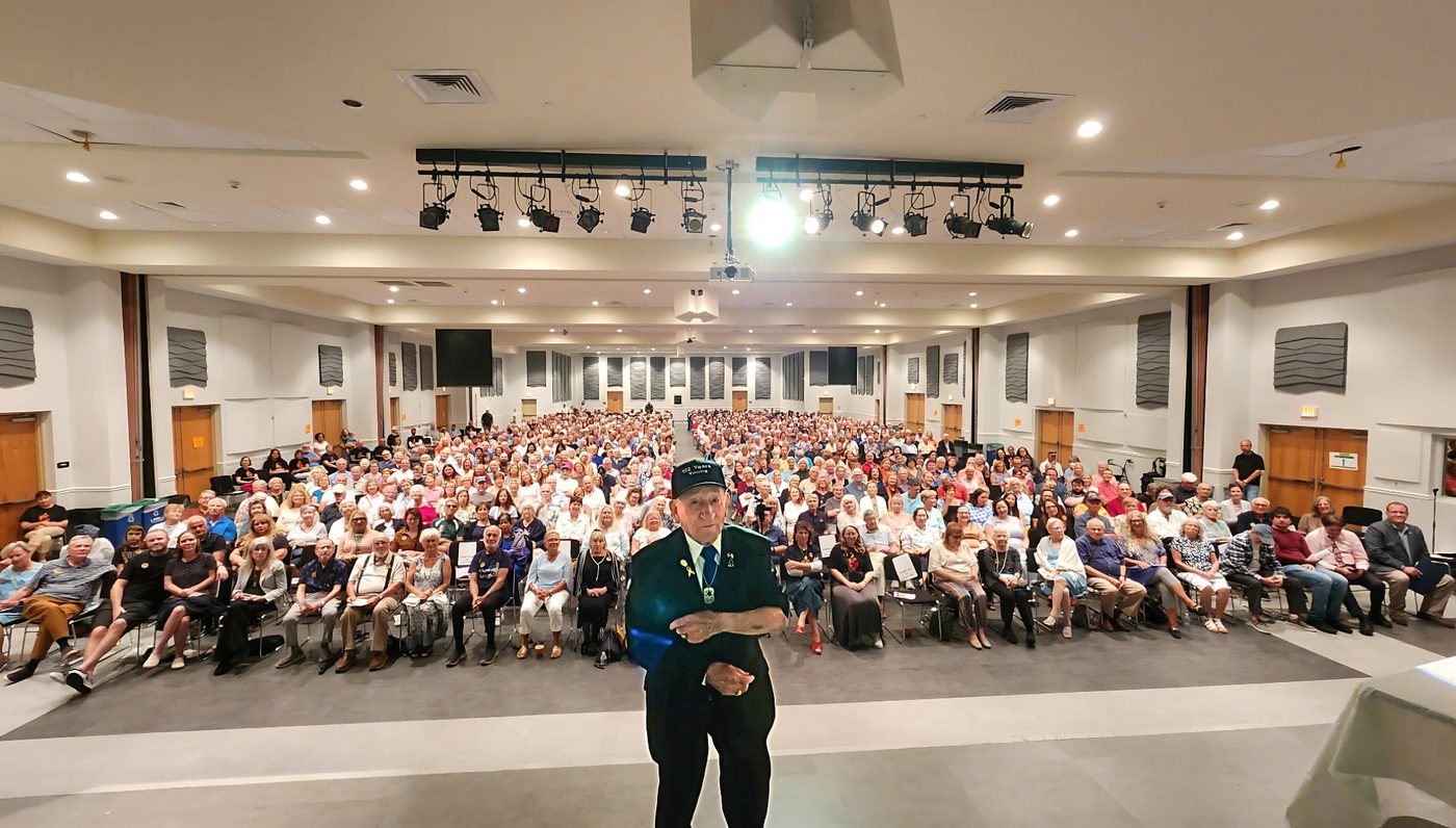 A Holocaust survivor addressing the full hall at our annual program